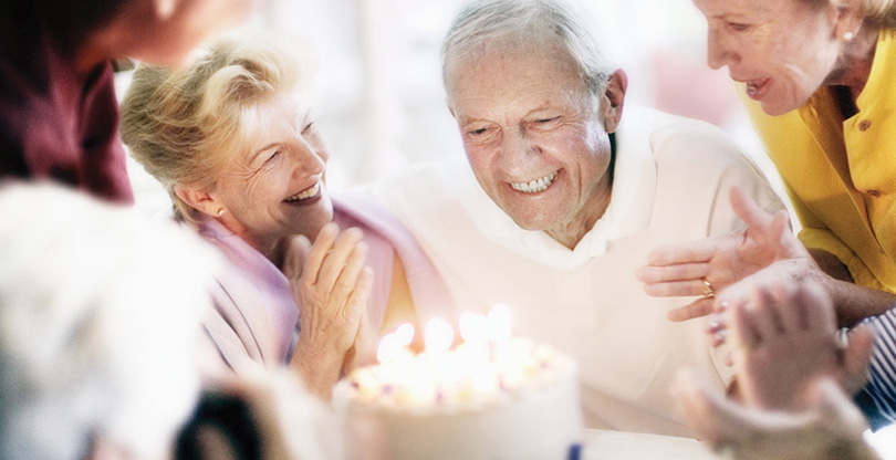Smiling older couple with a birthday cake