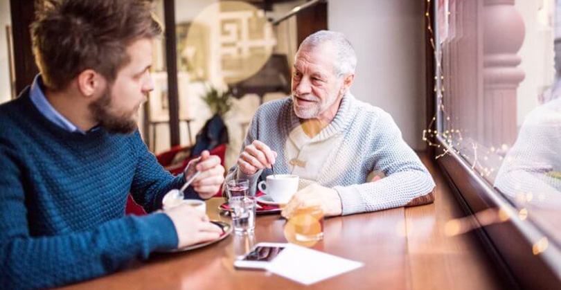older and younger man enjoying coffee together