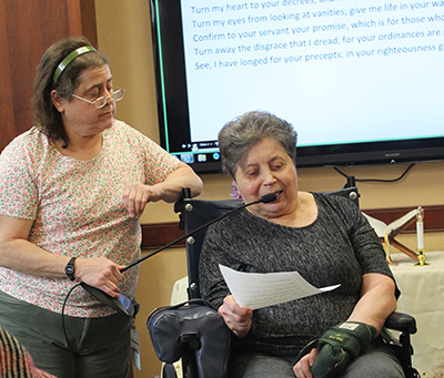 Patricia Romagna assists PAM resident Doris Short in reading a Psalm