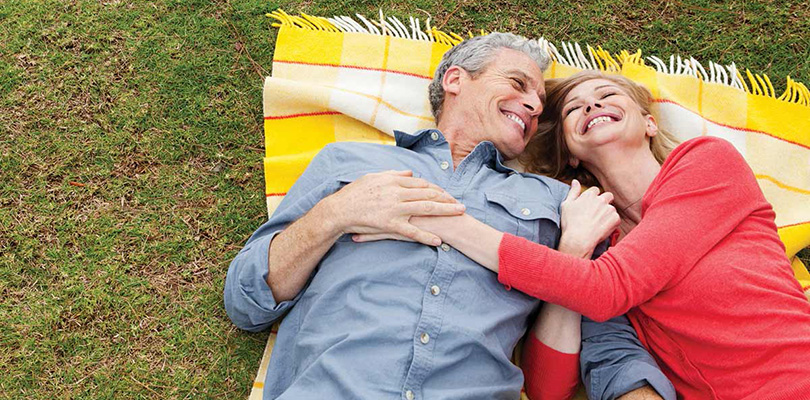 Couple laying on blanket on the grass